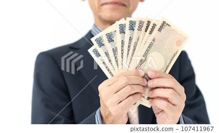 A man in a suit holding money 107411967