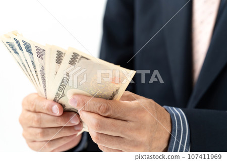 A man in a suit holding money 107411969
