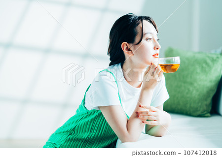 Young woman drinking tea. 107412018