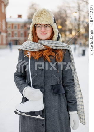 young European woman in winter clothes is skating young European woman in winter clothes is skating 107412125