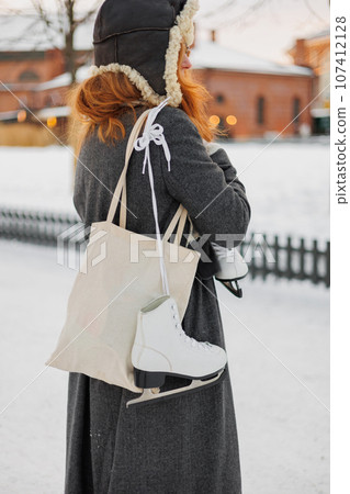 young European woman in winter clothes is skating young European woman in winter clothes is skating 107412128