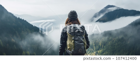 A young couple of hikers walk through the forest in rainy weather. 107412400