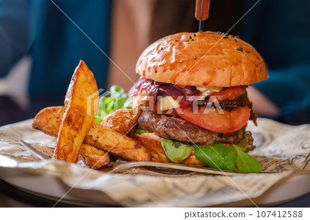 close-up of a plate of food with hamburger and french fries in a cafe. close-up of a plate of food with hamburger and french fries in a cafe. 107412588