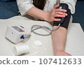 A woman measures her blood pressure. Self-medication concept. 107412633