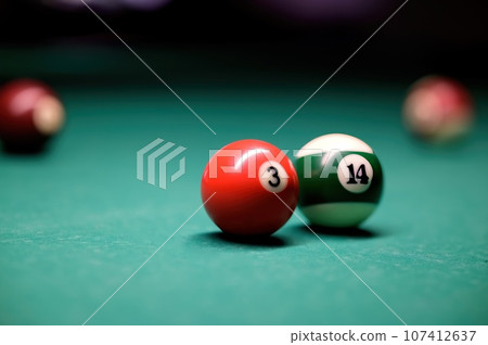 Billiard balls on the billiard table. A clean billiard table with several colored cue balls. 107412637