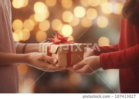 closeup detail of a girl's hands holding a gift on christmas morning closeup detail of a girl's hands holding a gift on christmas morning 107413027