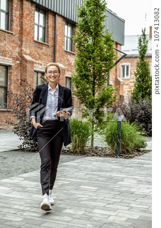 Good-looking young business woman looking contented and enjoyed 107413082