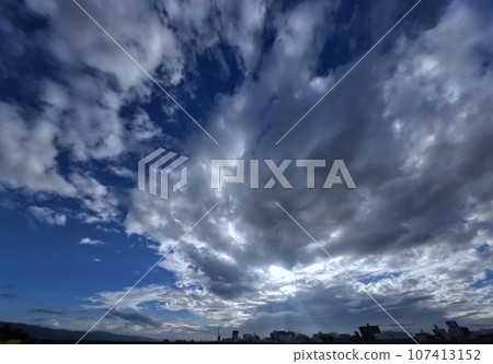 Early autumn morning sky with rays of light shining on the cityscape, ultra-wide angle, sky-based, 230918am 107413152