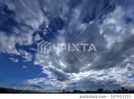 Early autumn morning sky with rays of light shining on the cityscape, ultra-wide angle, sky-based, 230918am 107413153