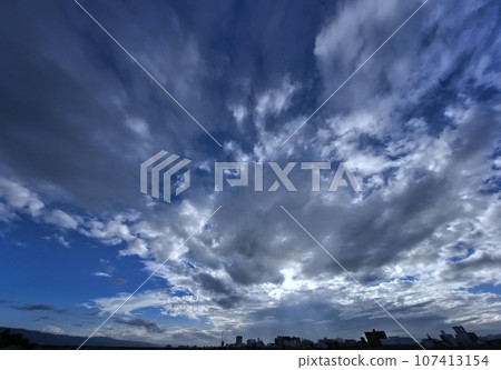 Early autumn morning sky with rays of light shining on the cityscape, ultra-wide angle, sky-based, 230918am 107413154