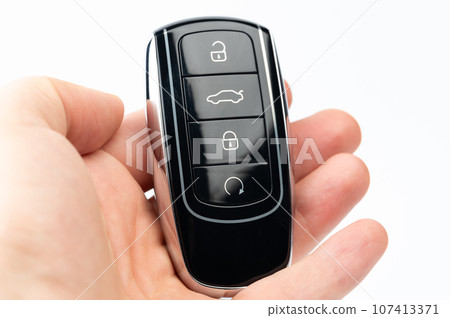 Modern black car key in palm hand Modern black car key in palm hand 107413371