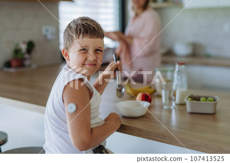 Diabetic boy with a continuous glucose monitor is careful with his diet. Diabetic boy with a continuous glucose monitor is careful with his diet. 107413525