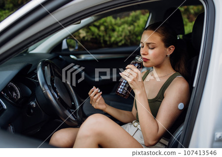 Woman with diabetes feeling dizzy during car drive. Woman with diabetes feeling dizzy during car drive. 107413546