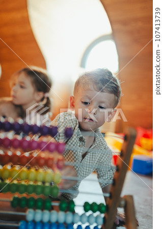 Little boy playing in the children's room with a wooden abacus. 107413739