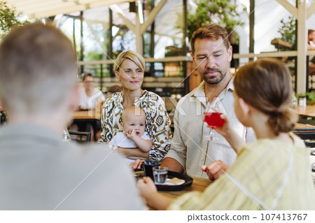 Big family with children and a small baby at family dinner in a restaurant. 107413767