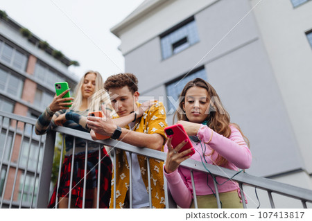Generation z students hanging out together outdoors in the city. Generation z students hanging out together outdoors in the city. 107413817
