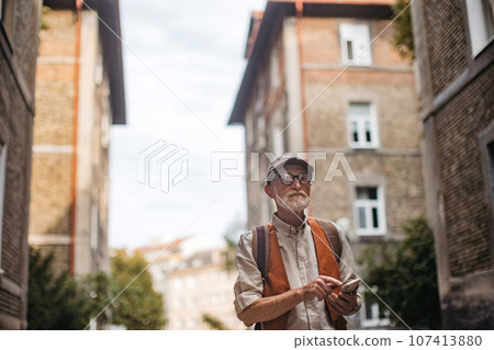 Senior tourist exploring a new city and visiting interesting sites. 107413880