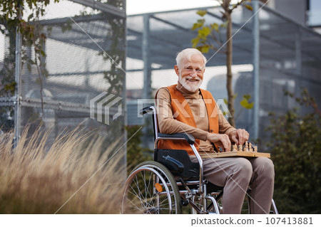 Senior man playing chess outdoors alone. Senior man playing chess outdoors alone. 107413881