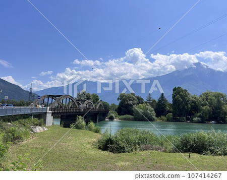 Bridge in Lombardy Ponte del Passo river ant mountains view 107414267