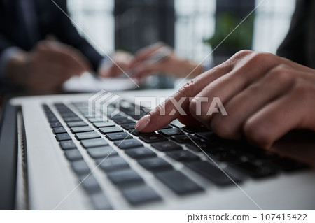 man's hands typing on laptop keyboard in interior man's hands typing on laptop keyboard in interior 107415422