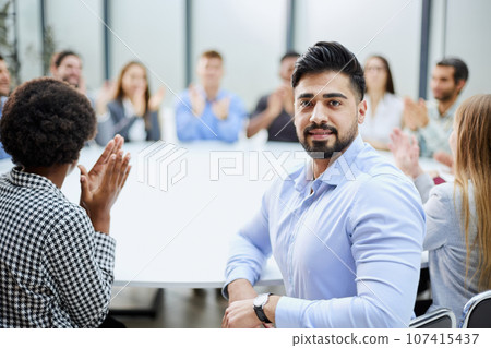 a man posing for the camera while sitting at a round table 107415437