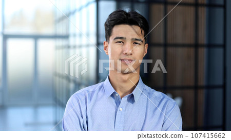 Close up portrait of young asian businessman standing in empty office 107415662