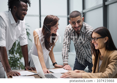 Happy young female worker discussing online project, showing presentation to experienced team leader in glasses. 107415668
