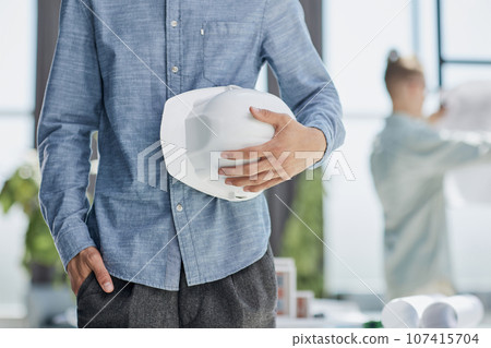 Close-up of a man holding a helmet in white 107415704