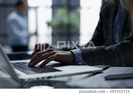 Close-up of male hands using laptop at office 107415715