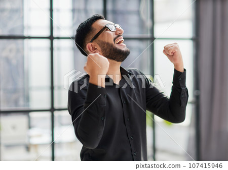 Portrait of a cheerful businessman celebrating his success 107415946