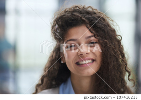 Cheerful girl standing at modern office looking at camera Cheerful girl standing at modern office looking at camera 107416213
