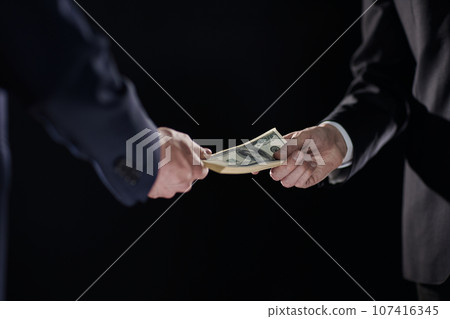 Money transfer between colleagues on a black background 107416345