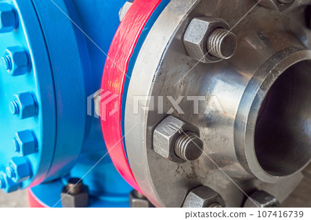 Close-up of steel pipe connection with bolts. Part of gas equipment. Gas industry. Background. 107416739