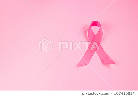 Pink ribbon on colored background. Breast Cancer Awareness Month symbol. Women's health care concept. Promotion of campaign to fight cancer. 107416834