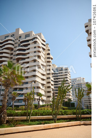 Contemporary high rise buildings with glass mirrored and geometric walls of modern Casablanca city under blue sky 107416861