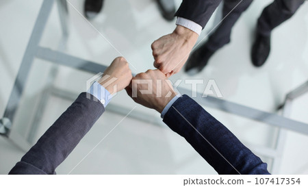 A group of successful businesspeople making fist bump together to cheer up, support and making a team spirit in the meeting 107417354