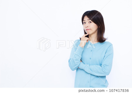 A woman in her thirties who is worried in front of a white background 107417836