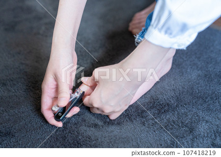 A woman cutting her toenails [parts cutting] 107418219