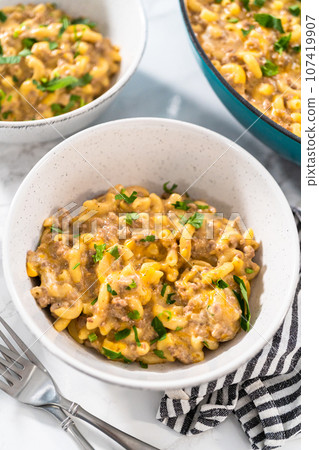 Serving homemade hamburger helper in white ceramic bowls. Serving homemade hamburger helper in white ceramic bowls. 107419907