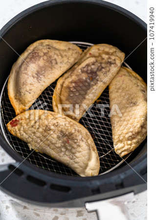 Frying sweet cherry empanadas in the air fryer. Frying sweet cherry empanadas in the air fryer. 107419940