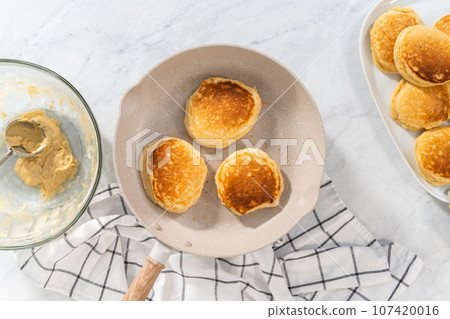 Flat lay. Preparing eggnog pancakes in a nonstick frying pan. 107420016