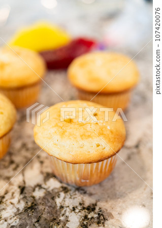 In the process of crafting delightful cactus cupcakes, the freshly baked vanilla and chocolate cupcakes are generously filled with tangy lemon and sweet raspberry filling, enhancing the flavors and 107420076