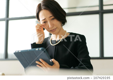 穿著喪服的女人看著平板電腦設備 107420195