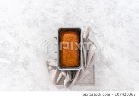 Flat lay. Colling freshly baked pumpkin bread on a kitchen cooling rack. Flat lay. Colling freshly baked pumpkin bread on a kitchen cooling rack. 107420362