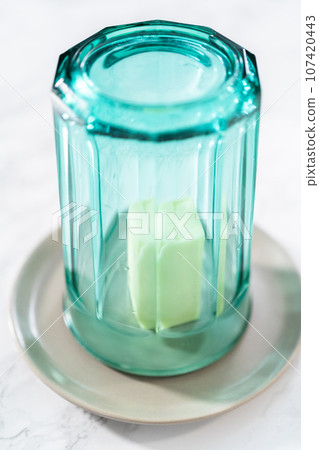 Softening stick of unsalted butter under a hot glass Softening stick of unsalted butter under a hot glass 107420443