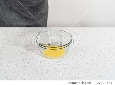 Whisking an egg to make an egg wash for sweet cherry empanadas. 107420644