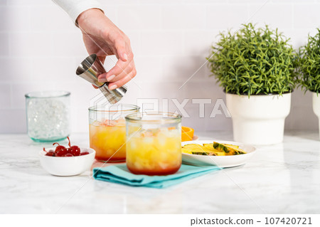 Step by step. Mixing Sunset cocktail with fresh ingredients. 107420721