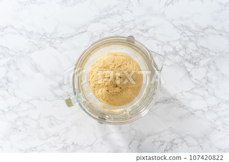 Mixing ingredients in kitchen mixer to bake mini Easter bread kulich. 107420822