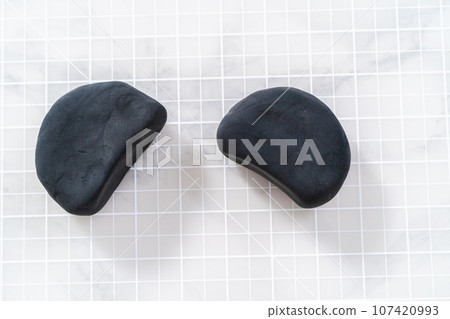 Making ears from black clay to make panda pumpkin for Halloween. 107420993