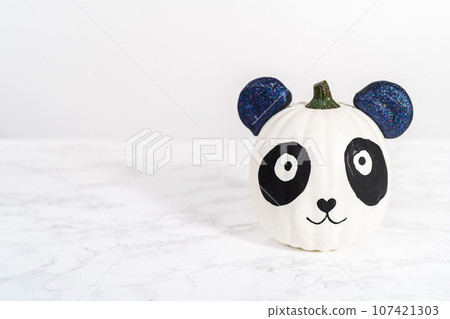 Panda pumpkin with glittery ears for Halloween on a white background. 107421303